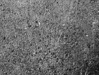 Dark asphalt road texture with rough stone granules, providing a realistic, high-resolution...