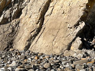 Beach rocks and steep cliff at the ocean in Santa Barbara, California