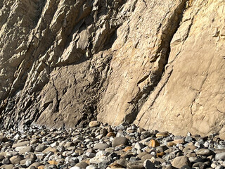 Beach rocks and steep cliff at the ocean in Santa Barbara, California
