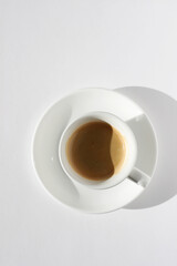 Espresso Coffee with Crema Foam Top View. Freshly Brewed Coffee in White Cup on White Background.
