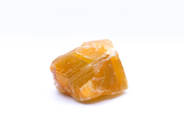 An image of a large unpolished honey calcite crystal on a white background.