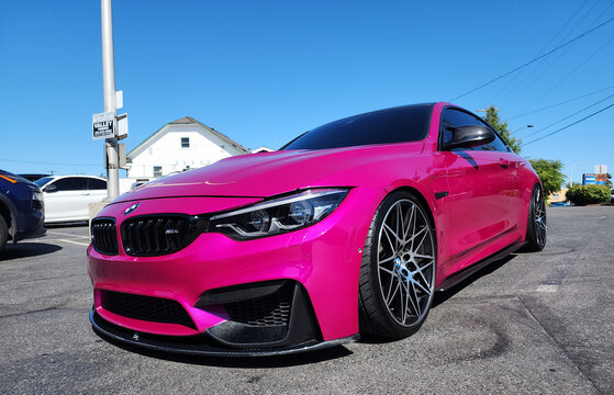 Seattle, WA, USA -July 19, 2024 : BMW F82 M4 Competition pink color corner front view. BMW F82 M4 is the sport version of BMW car.