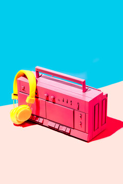 Vivid retro boombox with yellow headphones against two-tone background