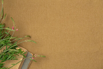 Vintage book with flowers on fabric background from above. Flat lay, top view. Copy space