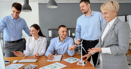 Group of engineers working with wind turbine models in office