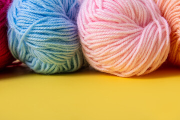 Yarn balls for knitting on yellow background. Threads of yarn closeup