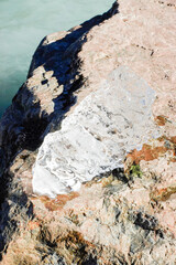 Piece of ice melting on a rock and sun reflecting on it