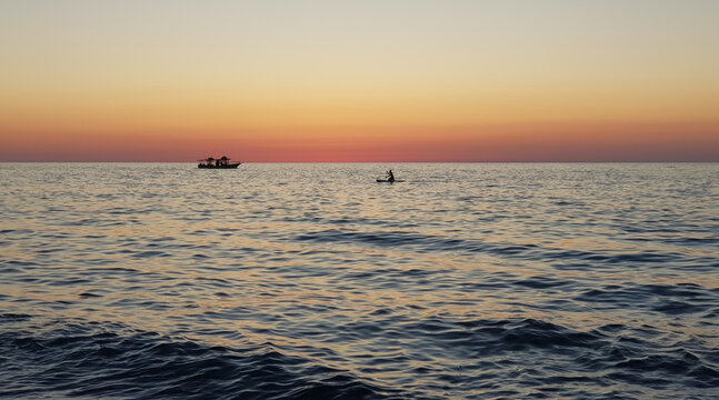 Sea at sunset with a boat silhouette, sunset over the sea 
