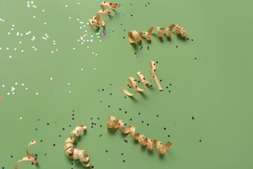 Christmas composition with ribbons and confetti on green background, closeup