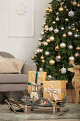 Christmas presents and fir tree branches on wooden sledge in living room, closeup