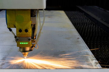 A laser cutting table in action, creating precise metal designs in a metal fabrication shop