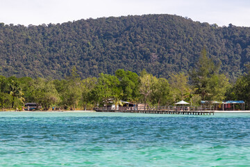 Simple houses on wooden piers and stilts in fishermen village Rach Vem on Phu Quoc island, Vietnam, South East Asia. Local fish farming and restaurants in turquoise water. Tropical jungle along coast