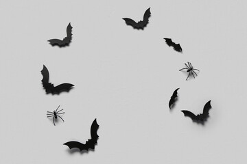Paper bats and spiders for Halloween party on grey background