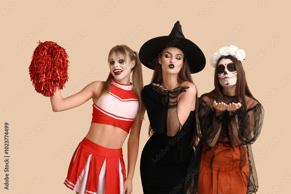 Wall mural Female friends dressed for Halloween on beige background