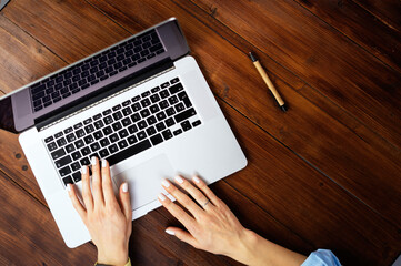 Closeup photo of female hands with a laptop. Female freelancer connecting to internet via computer....