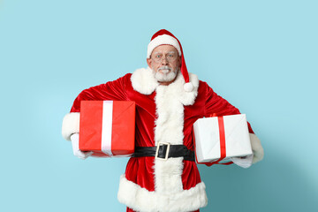 Santa Claus with gift boxes on blue background
