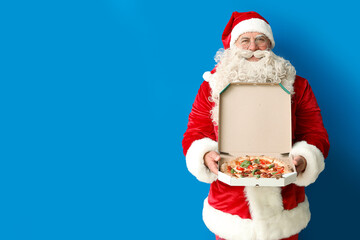 Santa Claus with box of tasty pizza on blue background