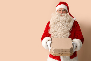 Santa Claus with pizza boxes on beige background