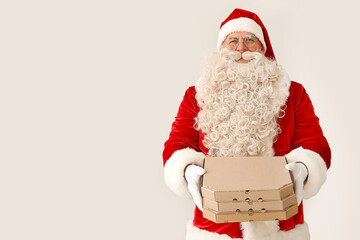 Santa Claus with pizza boxes on white background