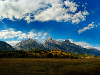 Grand Teton Mountains Tetons in Wyoming Rugged Mountain Range in Autumn Fall Landscape with blue sky and clouds