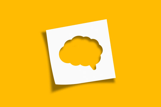 Mental health and problems with memory. Human brain shaped cut out on white note paper on yellow background.