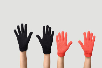 Hands in warm gloves on grey background