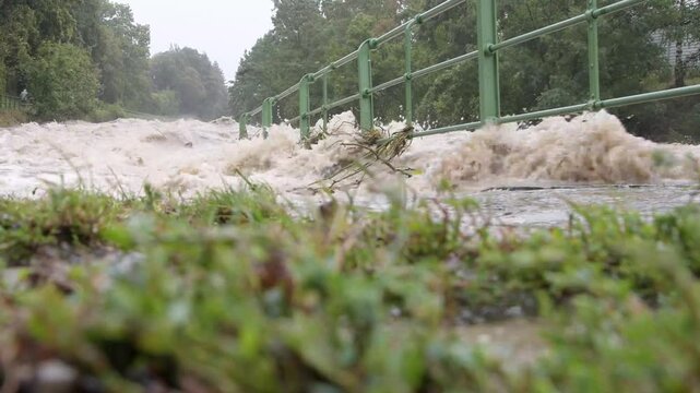 the river overflows its banks, flooding pedestrian