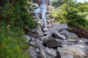 The girl walks on the stones in the mountains