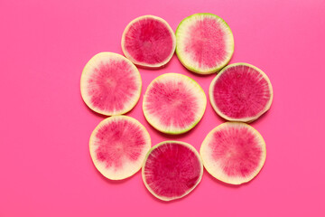 Slices of ripe watermelon radish on pink background