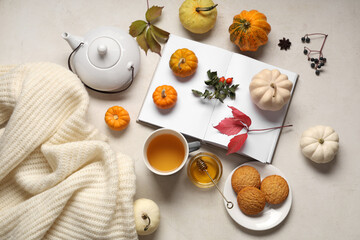 Autumn composition with cup of green tea, pumpkins and sweater on white background