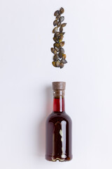 Pumpkin oil in glass bottle with seeds on white background