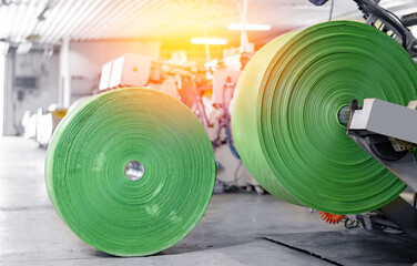 Automatic polyethylene plastic bag production, sunlight. Closeup roller of industry machine for...