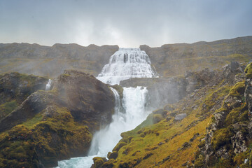 Dynjandi Waterfall, the tallest in Westfjords, Iceland, cascades down rugged cliffs with smaller...