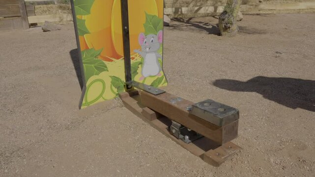 This video shows a test of strength hammer bell carnival game being played close up as the players hammer hits the bottom of the lever. 