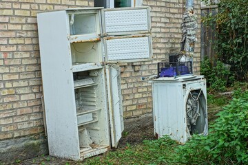 one tall three-chamber dirty open thrown away rusty white broken iron electric refrigerator...