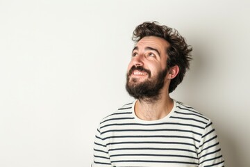 Obraz premium Handsome man in striped shirt smiling and thinking.
