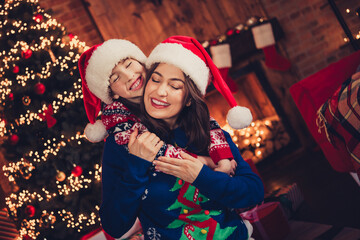 Portrait of two people mother daughter closed eyes cuddle festive christmas time illumination flat indoors