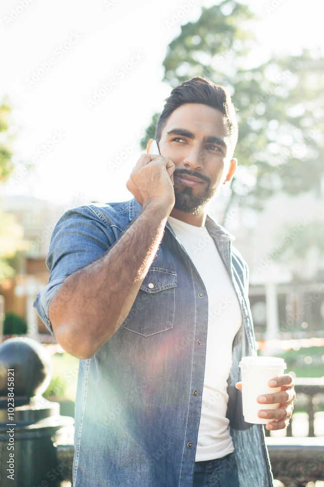 Poster turkish hipster guy with caffeine beverage in hand standing on city street during sunny summer day a