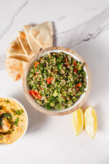 Tabbouleh Salad with Tomatoes, Pita Bread, Lemon Slices, and Hummus