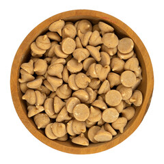 Overhead view of a small wood bowl filled with peanut butter baking chips isolated on a white background.