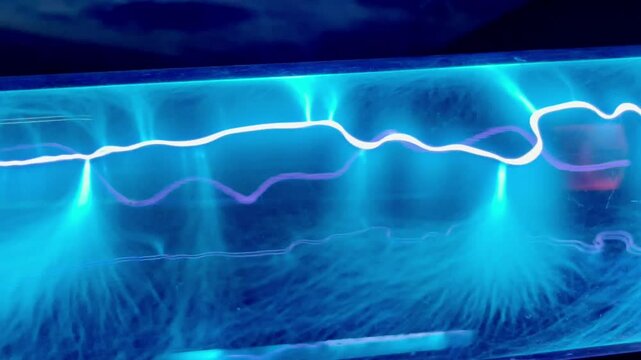 Blue neon gas discharge in plasma in transparent glass tube