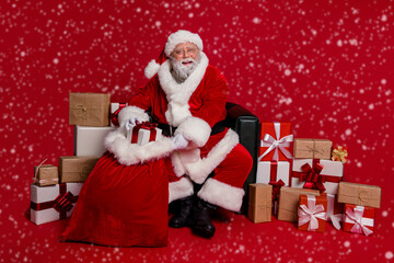 Photo of funky pretty santa claus wear red costume preparing gifts workshop isolated red color background