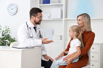 Doctor consulting little girl and her mother in hospital