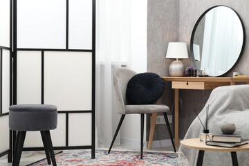 Mirror, dressing table, chairs and folding screen indoors. Interior design