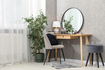 Mirror, dressing table, lamp, chair and houseplant indoors. Interior design