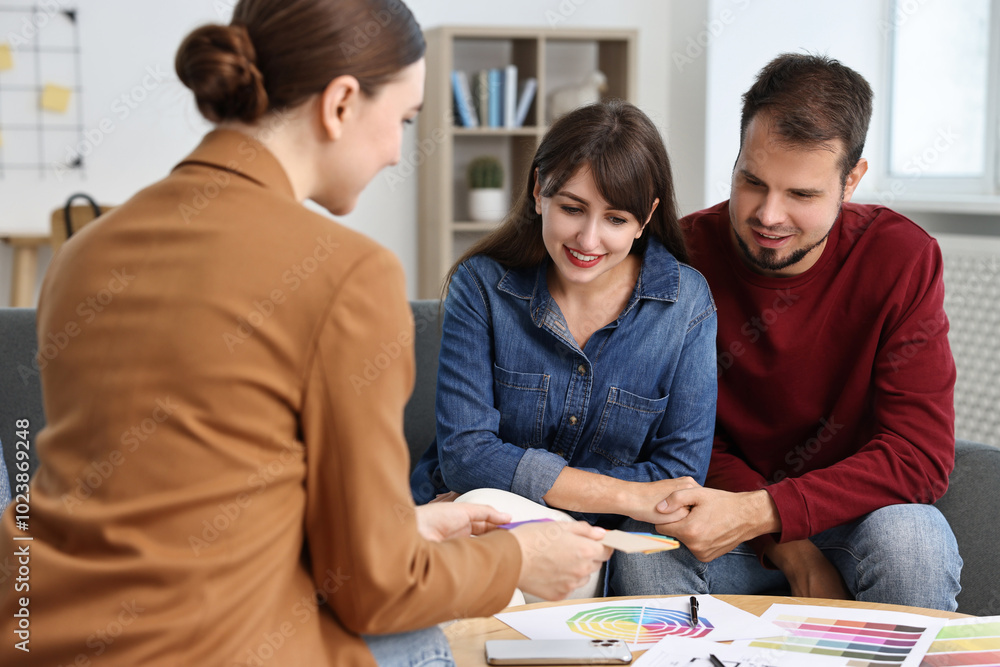 Poster designer discussing project with clients at table in office