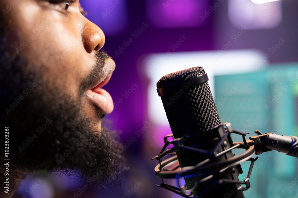 Poster young artist singing his new song creation on microphone gear, editing his recordings to adjust volu