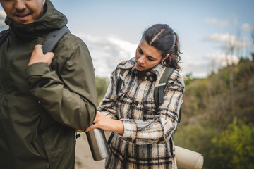 Fototapeta premium Girlfriend help boyfriend to pack and fasten his backpack