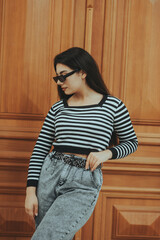 Confident Woman in Sunglasses Posing by Wooden Door
