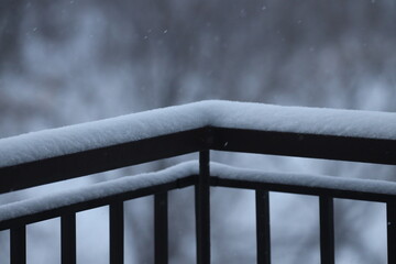 close-up new fallen snow covers tops of iron railings